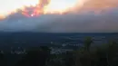 <p>Asap mengepul memancarkan cahaya di atas lingkungan di atas lingkungan di pinggiran Flagstaff, Arizona, Minggu (12/6/2022). Evakuasi telah diperintahkan untuk rumah-rumah di daerah tersebut. Pihak berwenang mengatakan petugas pemadam kebakaran menanggapi kebakaran hutan sekitar enam mil di utara Flagstaff yang telah memaksa evakuasi. (AP Photo/Felicia Fonseca)</p>