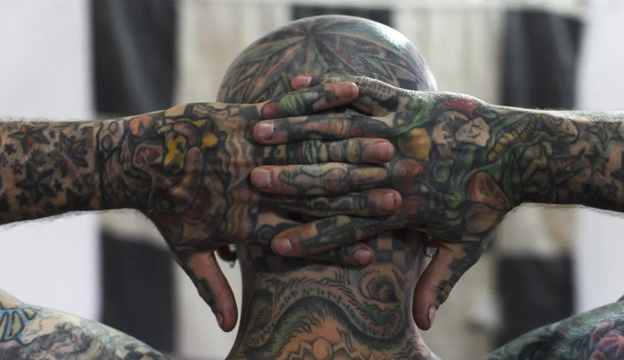 Matt Gone menunjukkan desain tato bagian belakang kepalanya di acara Guate Mayan Tattoo Convention di Kota Guatemala, Sabtu (19/7/14). (REUTERS/Jorge Dan Lopez)
