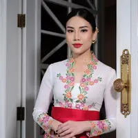 Angela Tanoesoedibjo tampil begitu menawan mengenakan kebaya model encim warna putih dengan aksen bordiran bunga warna-warni dan dipadukan dengan obi belt merah [Instagram/loritayoung_mua]