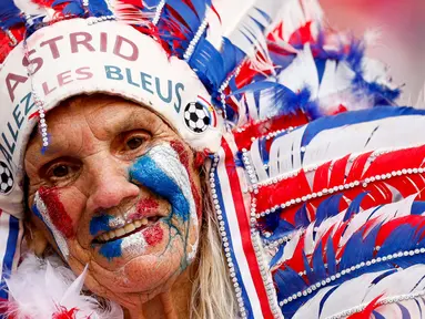 Seorang penggemar Prancis yang berdandan dan dirias berpose sebelum pertandingan sepak bola Grup D Euro 2024 antara timnas Belanda dan Prancis di Stadion Leipzig, Jerman, pada 21 Juni 2024. (Odd ANDERSEN/AFP)