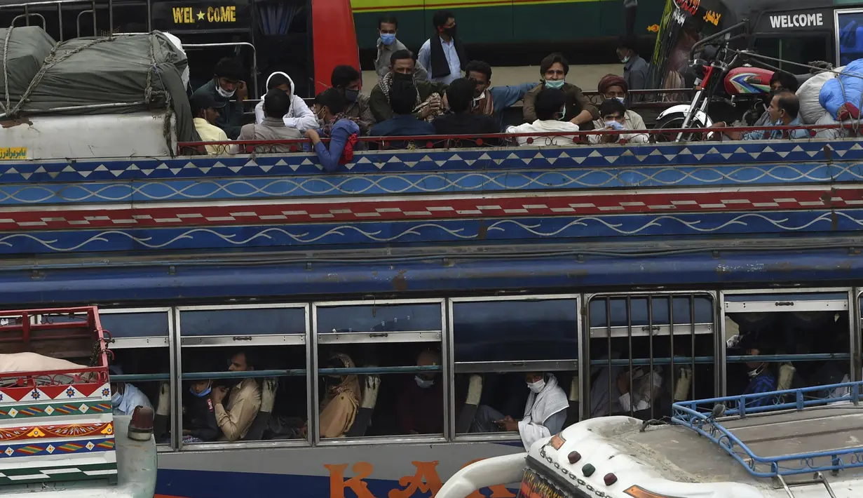 Warga berada di bus saat mereka melakukan perjalanan ke kampung halaman mereka menjelang perayaan Idul Fitri di Lahore (7/5/2021). Lebaran Idul Fitri jatuh pada 13 Mei 2021. (AFP Photo/Arif Ali)