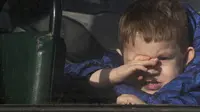 Seorang anak menunggu dalam bus untuk dievakuasi ke Rusia, di Donetsk, wilayah yang dikuasai oleh militan pro-Rusia, Ukraina timur, Sabtu (19/2/2022). Pada Jumat, otoritas separatis di Ukraina timur mengumumkan evakuasi massal perempuan, anak-anak dan orang tua ke Rusia. (AP Photo/Alexei Alexandrov)