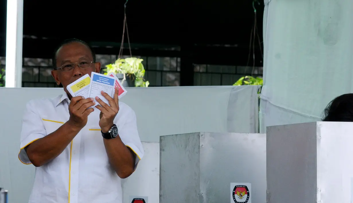Aburizal Bakrie menunjukkan kertas suara kepada rekan-rekan media yang kemudian dimasukkan kedalam kotak pengumpulan suara di TPS 32 Menteng, Jakarta Pusat, Rabu (9/4). Foto/Liputan6.com: Andrian Martinus Tunay 