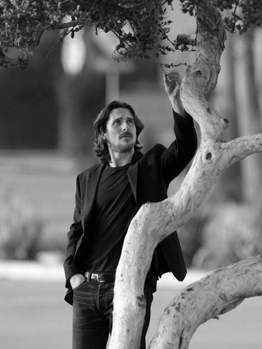<p>Christian Bale sedang ramai dibicarakan, karena penampilannya di film Thor: Love and Thunder. Salah satu gaya khasnya adalah tampil dengan rambut gondrong, lengkap dengan kumis dan jenggotnya, seperti dalam foto ini. Foto hitam putih yang menampakkan dirinya berpose di dekat sebuah pohon mengenakan kaus yang ditumpuk dengan blazer, dipadu celana jeans, lengkap dengan beltnya. Foto: Instagram.</p>