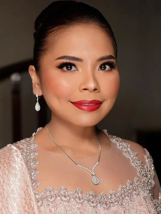 Di acara pernikahan sang adik, Felicia Hutapea tampil dalam balutan kebaya berpayet nuansa peach pink. [@djanurms.mua/@myrnamyura]