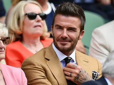 Mantan pesepak bola Inggris, David Beckham bersama ibunya, Sandra Georgina West menyaksikan babak semifinal Grand Slam Wimbledon di All England Lawn Tennis Club, Kamis (11/7/2019). David Beckham menonton aksi petenis Rumania Simona Halep di area Royal Box (tribun kerajaan). (Daniel LEAL-OLIVAS/AFP)