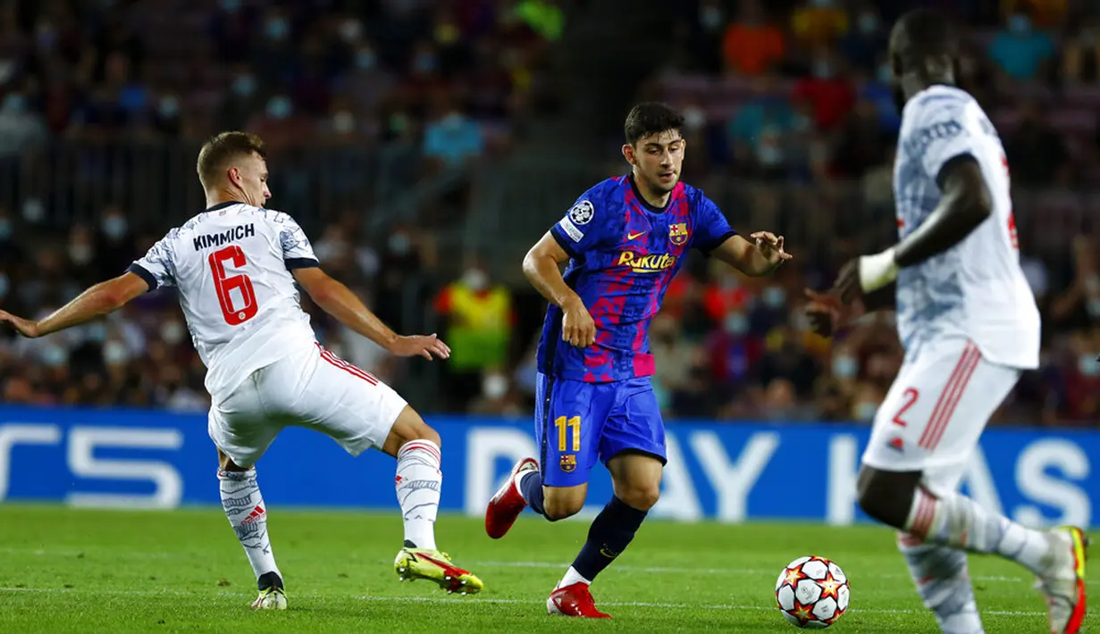 Pemain Barcelona Yusuf Demir (tengah) berebut bola dengan pemain Bayern Munchen Joshua Kimmich pada pertandingan Grup E Liga Champions di Stadion Camp Nou, Barcelona, Spanyol, Selasa (14/9/2021). Bayern Munchen menang 3-0. (AP Photo/Joan Monfort)