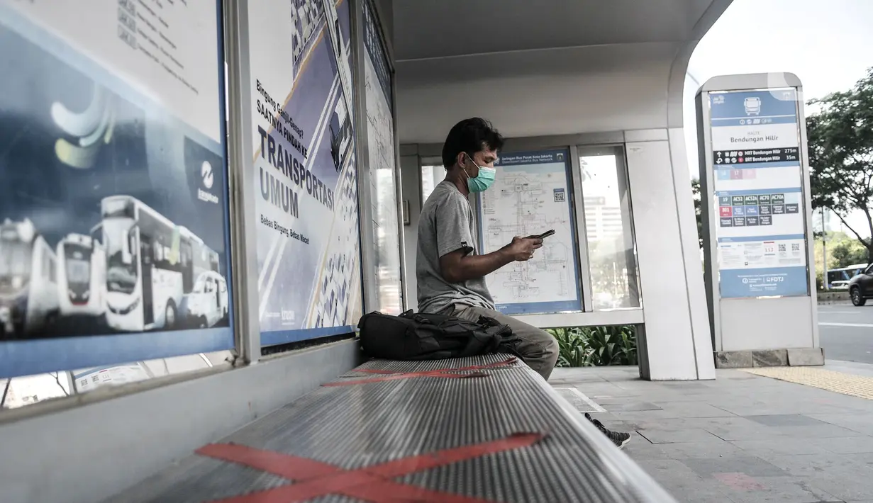 Warga duduk menunggu bus di dekat fasilitas cuci tangan di kawasan Sudirman, Jakarta, Selasa (1/9/2020). Dalam aturan tersebut tertulis PSBB Transisi di Jakarta diperpanjang hingga 10 September 2020. (merdeka.com/Iqbal S. Nugroho)