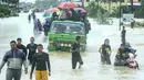 Sejumlah warga menggunakan mobil untuk menerobos banjir di Rantau Panjang, timur laut Malaysia, Selasa (3/1). Akibat hujan lebat yang turun terus menerus selama empat hari di Malaysia, 5.000 warga terpaksa dievakuasi. (AFP PHOTO/STR/Malaysia OUT)