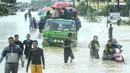 Sejumlah warga menggunakan mobil untuk menerobos banjir di Rantau Panjang, timur laut Malaysia, Selasa (3/1). Akibat hujan lebat yang turun terus menerus selama empat hari di Malaysia, 5.000 warga terpaksa dievakuasi. (AFP PHOTO/STR/Malaysia OUT)