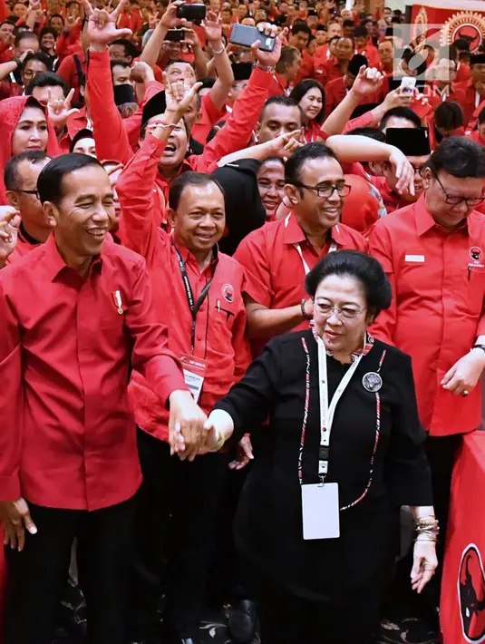 Presiden Joko Widodo atau Jokowi bergandengan tangan dengan Ketua Umum PDIP Megawati Soekarnoputri saat Rakernas PDIP III Tahun 2018 di Badung, Bali, Jumat (23/2). (Liputan6.com/Pool/Biro Pers Setpress)