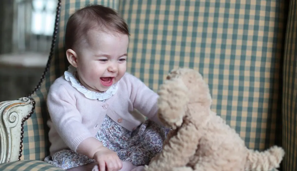 Foto ini diambil oleh Kate Middleton pada tahun 2015. Princess Charlotte terlihat bahagia banget ya main dengan boneka beruangnya! (Cosmopolitan)