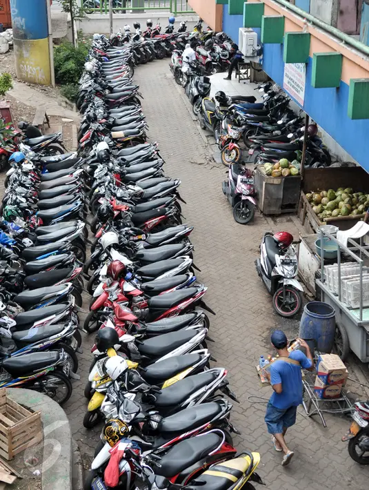 Seorang pedagang melewati lokasi parkir PD Pasar Jaya Tanah Abang, Jakarta, Senin (1/8). Mulai Agustus, Pemprov DKI melalui Badan Layanan Umum Daerah (BLUD) Perparkiran mengambil alih pengelolaan parkir 15 pasar PD Pasar Jaya. (Liputan6.com/Yoppy Renato)