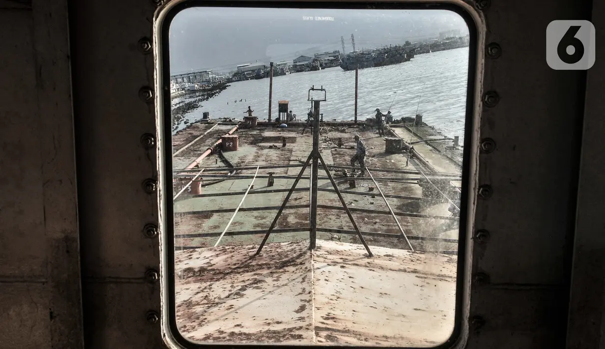 Aktivitas memancing di atas sebuah kapal karam di pesisir Kali Adem, Muara Angke, Jakarta, Minggu (27/12/2020). Sebuah kapal yang telah karam selama bertahun-tahun tersebut dimanfaatkan oleh warga sebagai tempat memancing meskipun berisiko membahayakan keselamatan. (merdeka.com/Iqbal Nugroho)