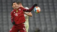 Penyerang Bayern Munchen Robert Lewandowski (Depan) berebut bola dengan bek Borussia Monchengladbach, Matthias Ginter pada laga pekan ke-18 Bundesliga di Allianz Arena, Sabtu (8/1/2022) dini hari WIB. Bayern Munchen dipermalukan di kandang sendiri 1-2. (CHRISTOF STACHE/AFP)