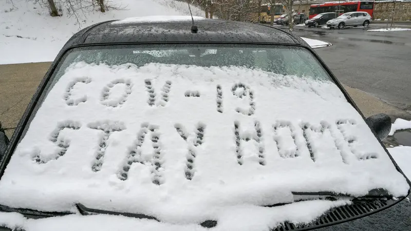 kata-kata "Kata-kata "COV-19 STAY HOME" ditulis di salju di kaca mobil di Budapest Hongaria pada 23 Maret 2020. (Attila Kisbenedek / AFP)COV-19 STAY HOME" ditulis di salju di kaca mobil pada 23 Maret 2020 di Budapest. ATTILA KISBENEDEK / AFP