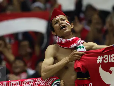 Suporter berteriak sambil membentangkan kaos jelang menyaksikan laga Timnas Indonesia melawan Vietnam pada semifinal pertama Piala AFF 2016 di Stadion Pakansari, Bogor, Sabtu (3/12). Indonesia unggul 2-1 atas Vietnam. (Liputan6.com/Helmi Fithriansyah)