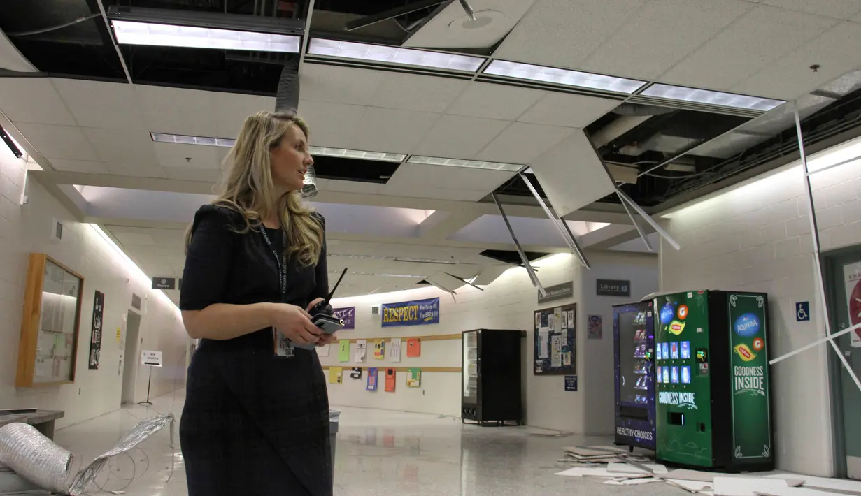 Allison Susel, kepala sekolah Chugiak High School melihat kerusakan menyusul gempa bumi di Chugiak, Alaska, Jumat (30/11). Gempa bermagnitudo 7.0 itu merobohkan langit-langit sekolah dan melemparkan buku-buku dari rak di perpustakaan (AP/Mark Thiessen)