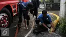 Petugas pemadam kebakaran (damkar) melakukan penyedotan genangan air di Pejaten Raya, Jakarta, Selasa (4/10). Akibat curah hujan yang tinggi menyebabkan sejumlah titik di Jakarta Selatan tergenang air. (Liputan6.com/Yoppy Renato)
