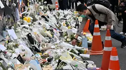 Seorang pria meletakkan bunga di sebuah peringatan darurat untuk para korban akibat kerumunan massa dalam tragedi Halloween yang mematikan, di luar stasiun kereta bawah tanah di distrik Itaewon di Seoul, Kamis (3/11/2022). Bencana itu adalah yang paling mematikan di negara itu sejak tenggelamnya feri tahun 2014 yang menewaskan 304 orang, terutama siswa sekolah menengah. (Jung Yeon-je / AFP)