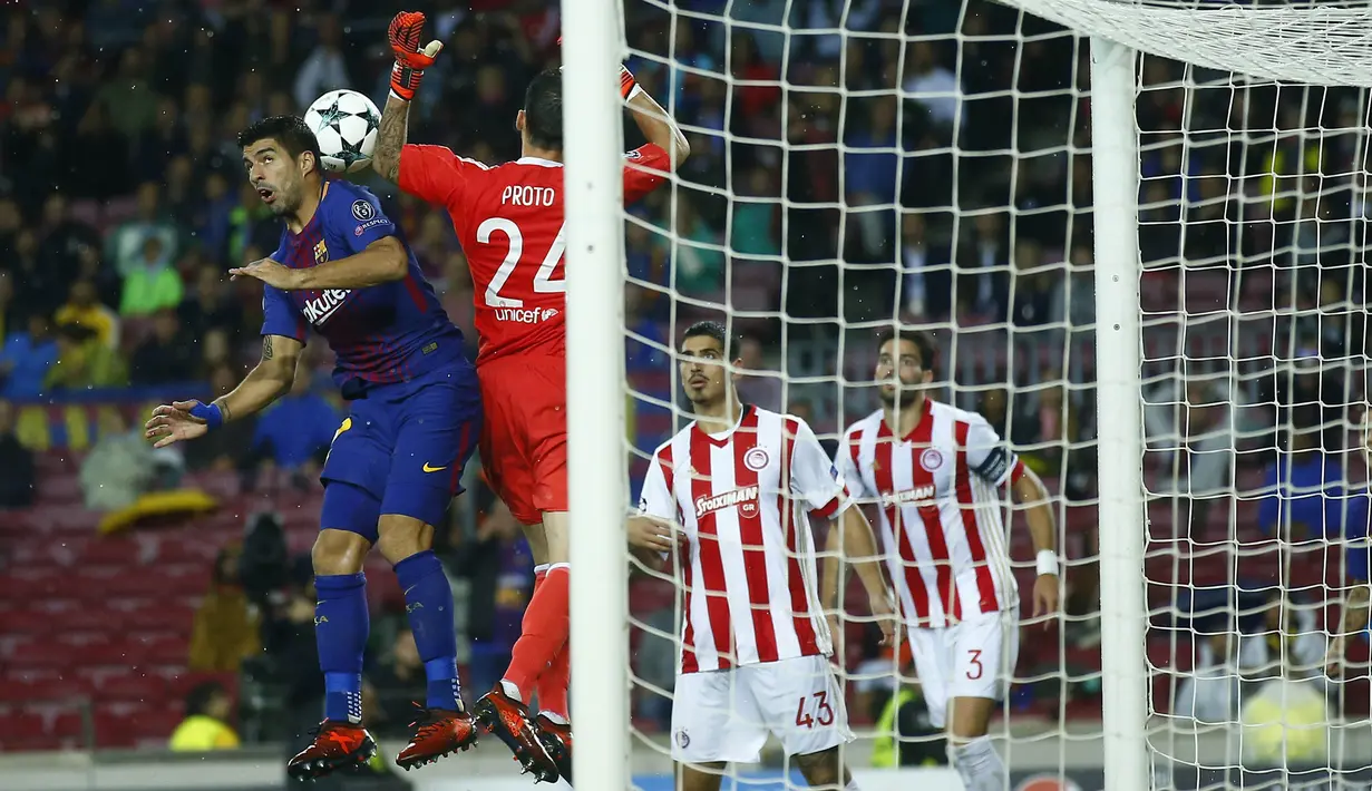 Striker Barcelona, Luis Suarez, duel udara dengan kiper Olympiakos, Silvio Proto pada laga Liga Champions di Stadion Camp Nou, Kamis (19/10/2017). Barcelona menang 3-1 atas Olympiakos. (AP/Manu Fernandez)