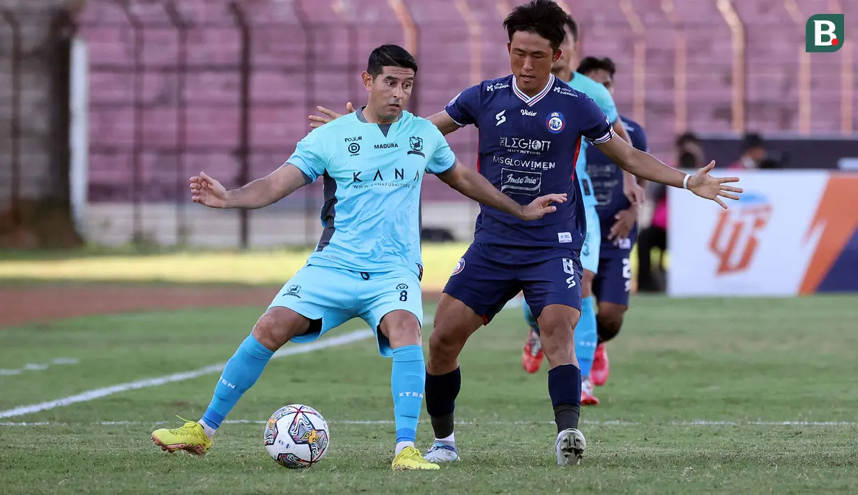 <p>Pemain Madura United, Esteban Vizcarra (kiri) menguasai bola dibayangi pemain Arema FC, Renshi Yamaguchi dalam laga pekan ke-16 BRI Liga 1 2022/2023 di Stadion Sultan Agung, Yogyakarta, Selasa (20/12/2022) sore WIB. (Bola.com/Ikhwan Yanuar)</p>
