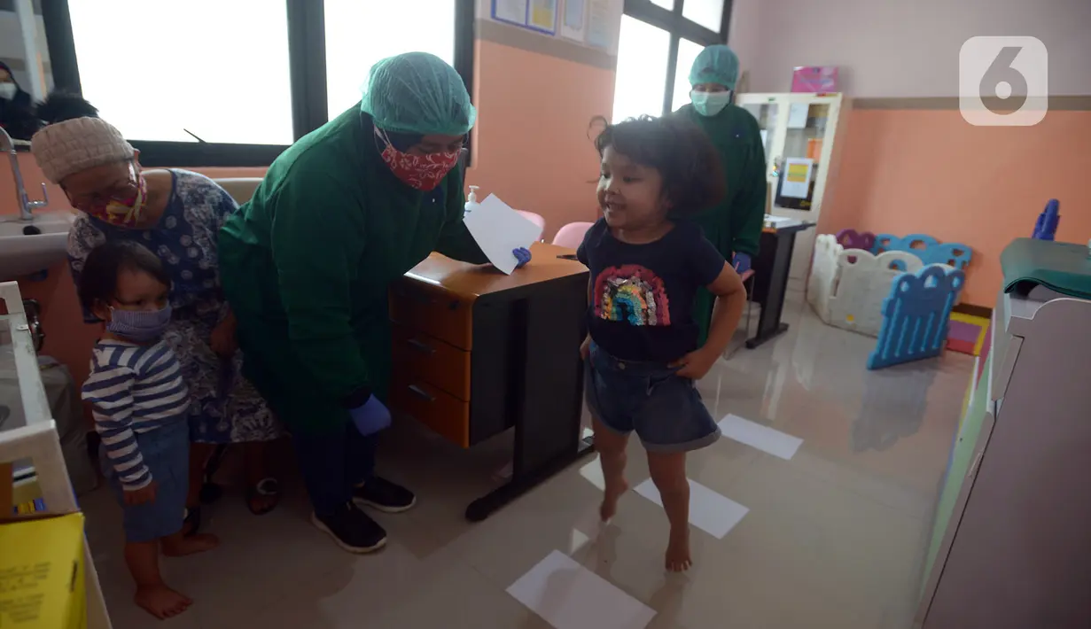 Dokter memeriksa stimulasi deteksi dan intervensi dini tumbuh kembang anak usia 5 dan 2 tahun di Puskesmas Kramat Jati, Jakarta, Kamis (12/11/2020). Pemantauan pertumbuhan balita dan batita dilakukan dengan imunisasi secara rutin pada anak usia 0-9 bulan dan 18 bulan. (merdeka.com/Imam Buhori)