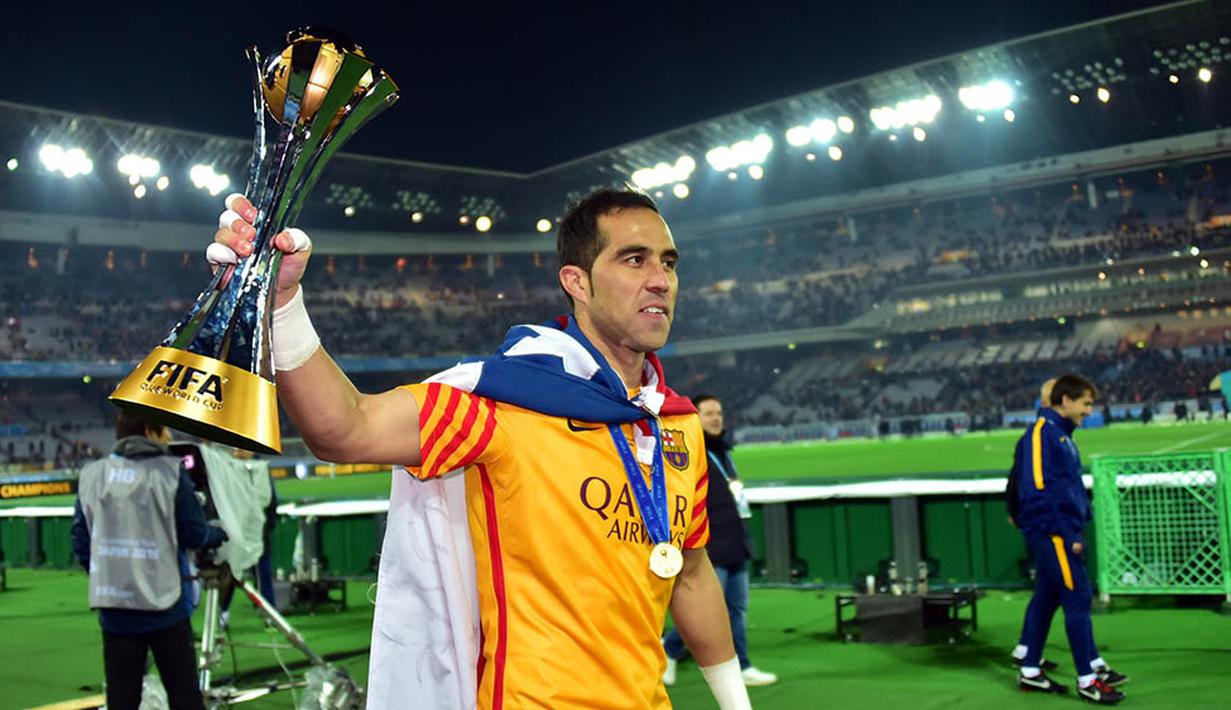 Kiper Barcelona, Claudio Bravo, mengangkat piala saat merayakan juara Piala Dunia Antarklub 2015. (AFP/Yoshikazu Tsuno)