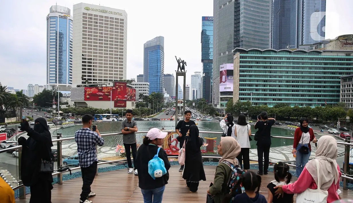 Aktivitas warga di Anjungan Halte Transjakarta Bundaran Hotel Indonesia Astra, Jakarta, Senin (27/1/2025). (Liputan6.com/Angga Yuniar)
