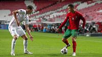 Striker Portugal, Cristiano Ronaldo, berusaha melewati bek Prancis, Benjamin Pavard, pada laga UEFA Nations League di Stadion Da Luz, Minggu (15/11/2020). Prancis menang dengan skor 1-0. (AP/Armando Franca)