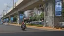 Pengendara melintasi videotron penghormatan kepada tenaga medis yang gugur akibat Covid-19 di tiang penyangga lintasan MRT, Jalan Sisingamangaraja, Jakarta, Jumat (18/9/2020). Keberadaan videotron tersebut diharap mampu membuat masyarakat waspada akan ancaman Covid-19. (Liputan6.com/Herman Zakharia)