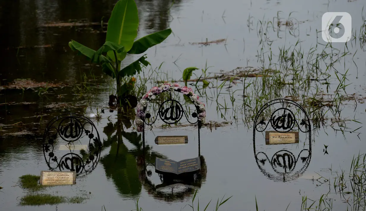 Sejumlah makam di Tempat Pemakaman Umum (TPU) Tanah Kusir terendam banjir, Jakarta, Jumat (3/1/2020). TPU Tanah Kusir terendam banjir setelah Kali Pesanggrahan meluap akibat intensitas hujan  yang tinggi pada Rabu lalu. (merdeka.com/Imam Buhori)