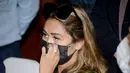 Leia Se, perempuan asal Rusia merapikan masker saat menghadiri konferensi pers sebelum dideportasi di kantor Kemenkumham Bali, Rabu (5/5/2021). Leia Se diamankan pihak imigrasi karena membuat konten prank melukis wajah mirip masker di Bali akhirnya dideportasi. (AFP/Sonny Tumbelaka)