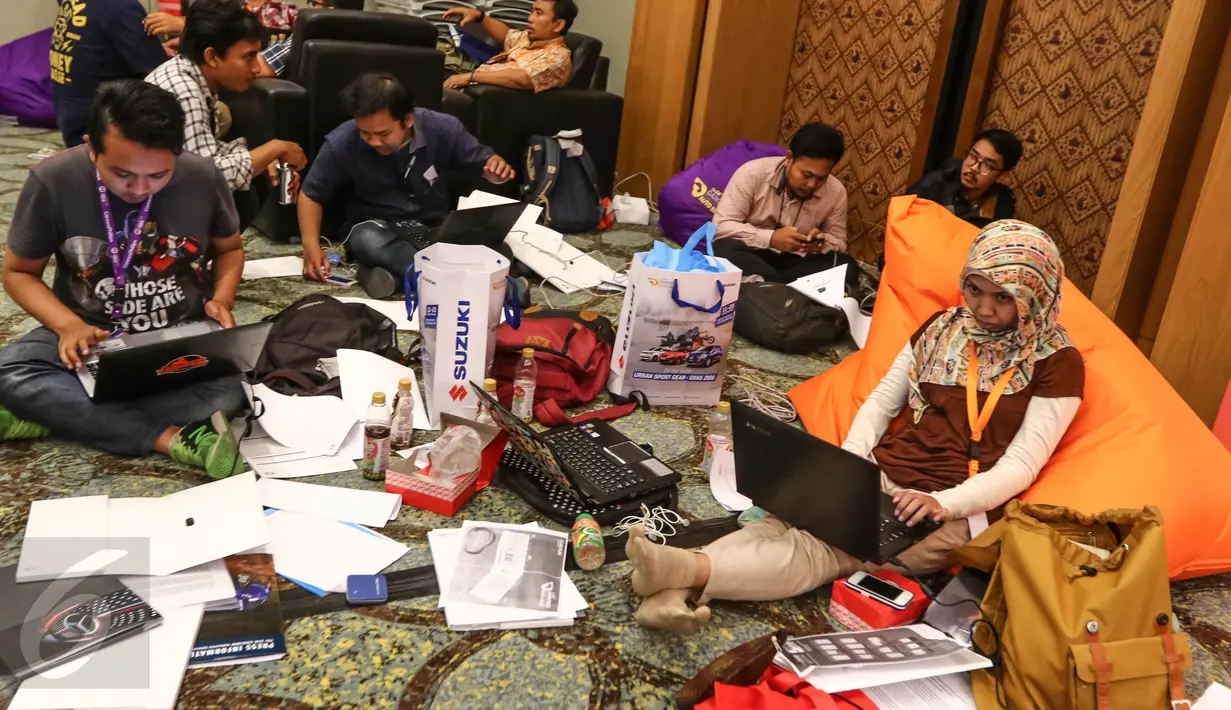  Sejumlah jurnalis sedang mengetik berita dengan kertas yang berserakan saat Gaikindo Indonesia International Auto Show (GIIAS) di pressroom ICE BSD, Tangerang Selatan (11/08). (Liputan6.com/Fery Pradolo)