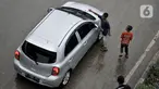 Seorang anak membersihkan kaca mobil yang melintas di Jalan Raya Bekasi, Cakung, Jakarta, Selasa (17/3/2020). Akibat keterbatasan ekonomi, anak-anak yang masih duduk di bangku sekolah dasar ini nekat menawarkan jasa membersihkan kaca mobil dan truk di jalan raya. (merdeka.com/Iqbal S Nugroho)
