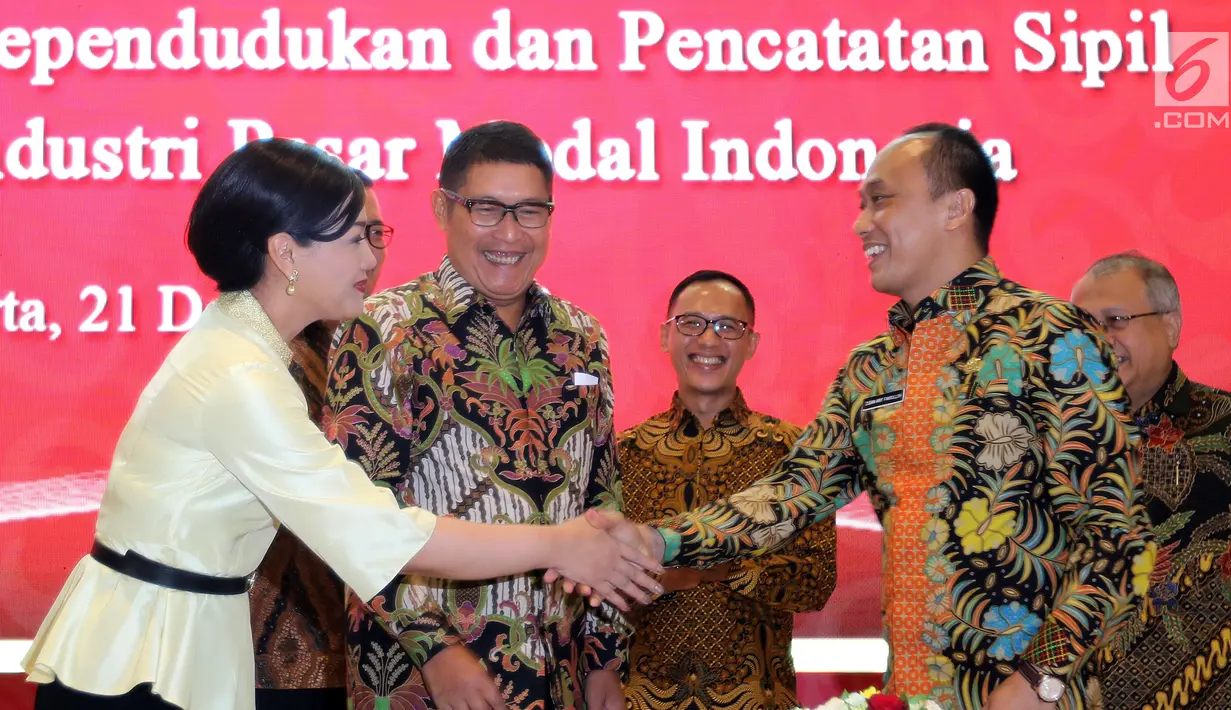 Dirjen Dukcapil Zudan Arif Fakrulloh (kanan) bersalaman dengan Dirut KSEI Friderica Widyasari Dewi usai penandatanganan kerja sama pemanfaatan data Ditjen Dukcail dengan 104 pelaku industri pasar modal, Jakarta, Jumat (21/12). (Liputan6.com/JohanTallo)