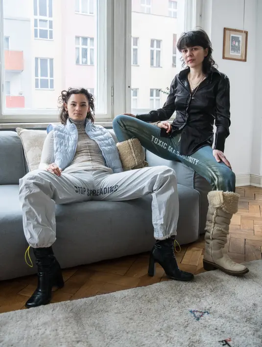Elena Buscaino (kiri) dan Mina Bonakdar berpose dengan Riot Pants mereka di Berlin pada 5 Februari 2021. Aktivis feminis itu sedang dalam misi menghentikan manspreading -- kebiasaan buruk penumpang pria yang duduk dengan kaki melebar sehingga memakan dua kursi kereta sekaligus. (STEFANIE LOOS/AFP)