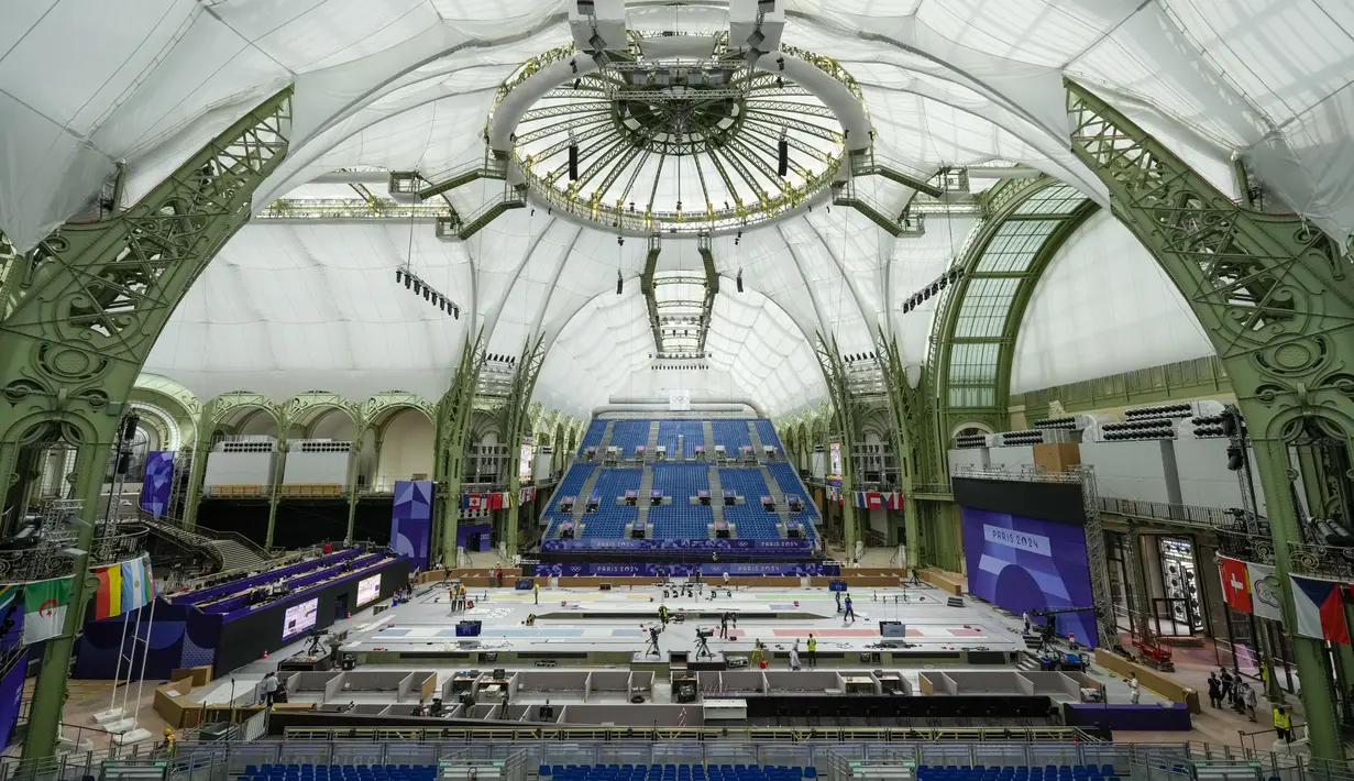 Para pekerja melakukan sentuhan akhir pada Grand Palais, Selasa, 23 Juli 2024, di Paris, Prancis. (AP Photo/Andrew Medichini)