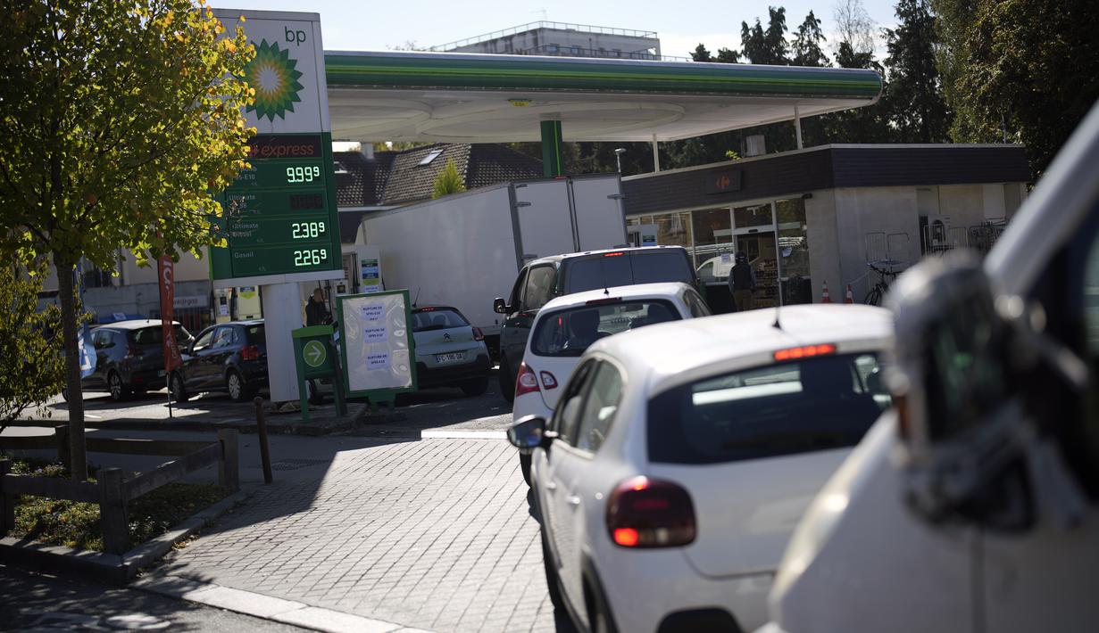 Pengemudi mengantre saat mereka menunggu untuk membeli bensin di sebuah pompa bensin di Paris, Selasa (11/10/2022). Aksi mogok kerja mengakibatkan pengiriman BBM berkurang, sehingga menimbulkan kekhawatiran dan antrean panjang. (AP Photo/Christophe Ena)