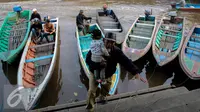 Pria menggendong anaknya turun dari perahu sampan di Sungai Kapuas, Pontianak, Kalimantan Barat, Sabtu (22/8/2015). Perahu Sampan saat ini masih diminati warga sebagai pilihan moda transportasi sederhana di Sungai Kapuas. (Liputan6.com/Faizal Fanani)