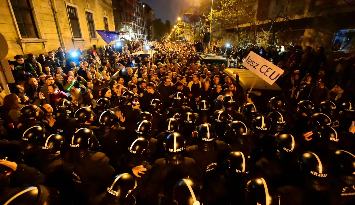 Polisi berjaga-jaga saat unjuk rasa menolak kebijakan baru terkait aturan baru bagi perguruan tinggi asing, Hungaria, Minggu (9/4). (AFP PHOTO/ATTILA KISBENEDEK)