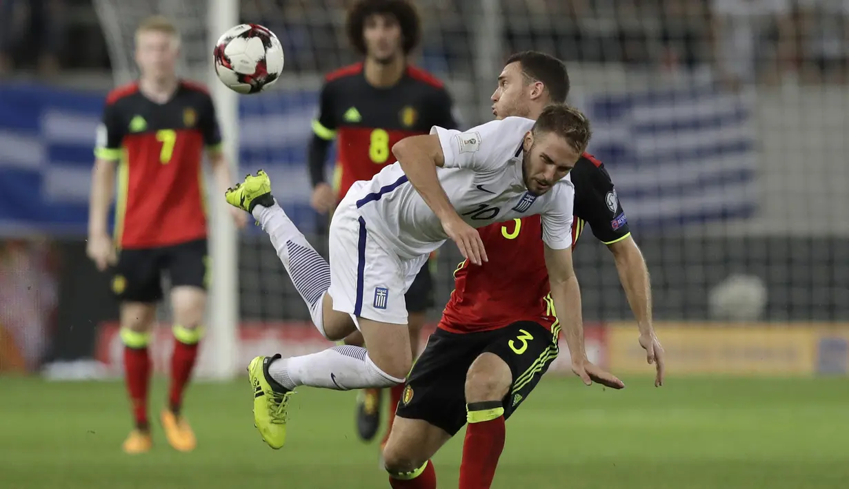 Pemain Yunani, Kostas Fortounis berebut bola dengan pemain Belgia, Thomas Vermaelen (kanan) pada laga grup H kualifikasi Piala Dunia 2018 di Georgios Karaiskakis Stadium, Piraeus port, Yunani, (3/9/2017). Belgia menang 2-1. (AP/Yorgos Karahalis)