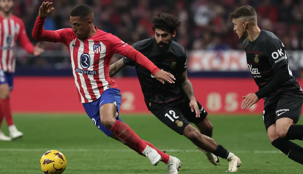 Penyerang Atletico Madrid #12 Samuel Lino (kiri) berebut bola dengan gelandang Real Mallorca #12 Samu Costa pada lanjutan Liga Spanyol di Stadion Wanda Metropolitano, Minggu (26/11/2023). (Thomas COEX / AFP)