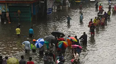 Orang-orang mengarungi jalan yang banjir setelah hujan lebat di Chennai, India (8/11/2021). Chennai dilanda Curah Hujan Terberat Sejak 2015,  Pihak berwenang Keluarkan Peringatan Banjir. (AFP/Arun Sankar)