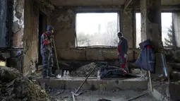 Pekerja kota membersihkan di dalam gedung balai kota yang terbakar di Almaty, Kazakhstan, Kamis (13/1/2022). Aksi protes massal di Kazakhstan dimulai pekan lalu dengan cepat menyebar ke kota terbesar yang juga pusat ekonomi Kazakhstan, Almaty, serta kota-kota lain. (Vladimir Tretyakov/NUR.KZ via AP)