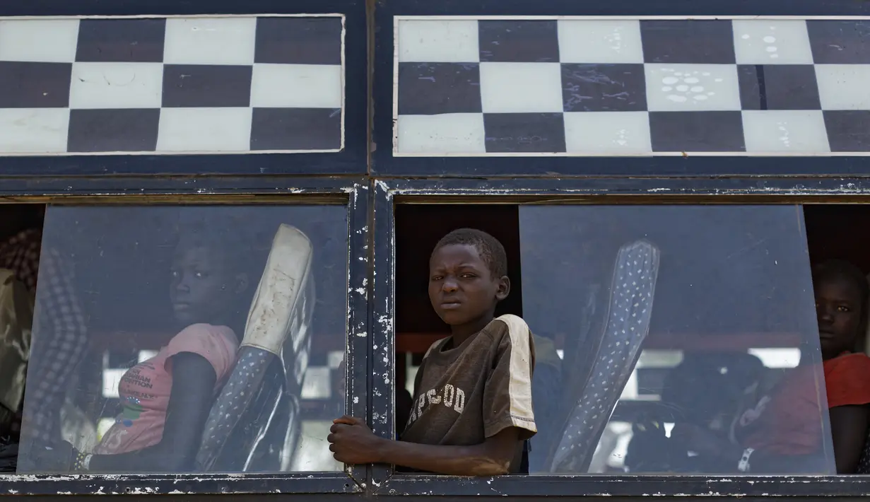 Seorang anak berada di bis yang akan membawanya ke Bidi Bidi, Uganda, Selasa (6/6). Bidi Bidi adalah pemukiman pengungsi terbesar di dunia yang menampung pengungsi Sudan Selatan. (AP Photo / Ben Curtis)