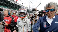 Pebalap F1, Fernando Alonso, berjalan kembali garasi setelah mobilnya mengalami kerusakan mesin pada balapan debutnya di ajang Indy 500, Minggu (28/5//2017) waktu setempat. (AP Photo/Sam Riche)