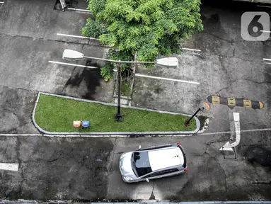 Sebuah mobil melintas di lahan parkir yang sepi di sebuah gedung, Jakarta, Kamis (1/5/2020). Indonesia Parking Association (IPA) menyatakan terjadi penurunan bisnis parkir sebesar 75-90 persen seiring penerapan PSBB untuk mencegah penyebaran COVID-19 di Jabodetabek. (Liputan6.com/Faizal Fanani)