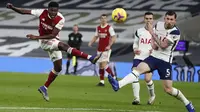 Gelandang Arsenal, Thomas Partey menembak bola dari kawalan bek Totttenham Hotspur, Emile Hojbjerg pada pertandingan lanjutan Liga Inggris di Tottenham Hotspur Stadium di London, Inggris , Minggu (7/12/2020). Tottenham menang 2-0. (Paul Childs/Pool via AP)