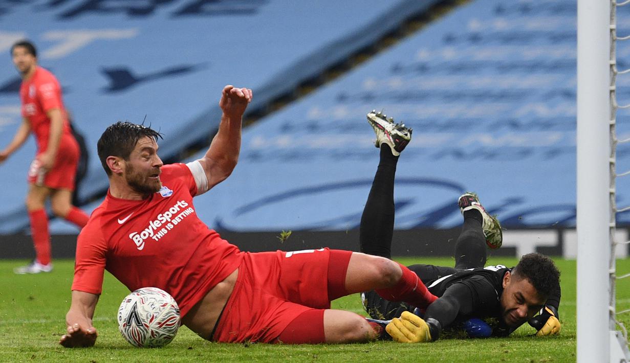 Striker Birmingham City, Lukas Jutkiewicz (kiri) berduel dengan kiper Manchester City, Zack Steffen dalam laga babak ke-3 Piala FA 2020/21 di Etihad Stadium, Minggu (10/1/2021). Birmingham City kalah 0-3 dari Manchester City. (AFP/Oli Scarff/Pool)